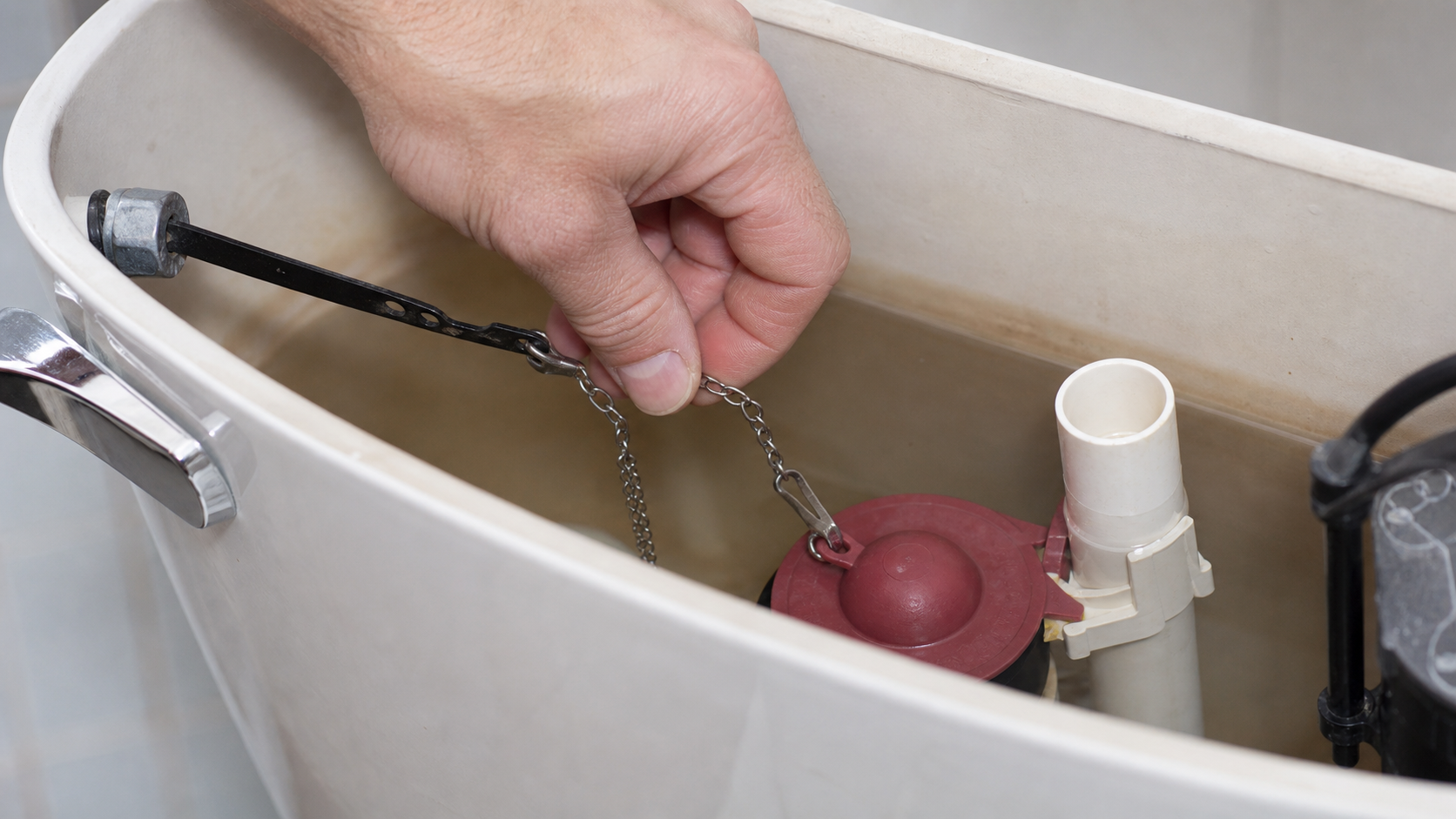 Test au colorant alimentaire versé dans un réservoir pour détecter une fuite de toilette