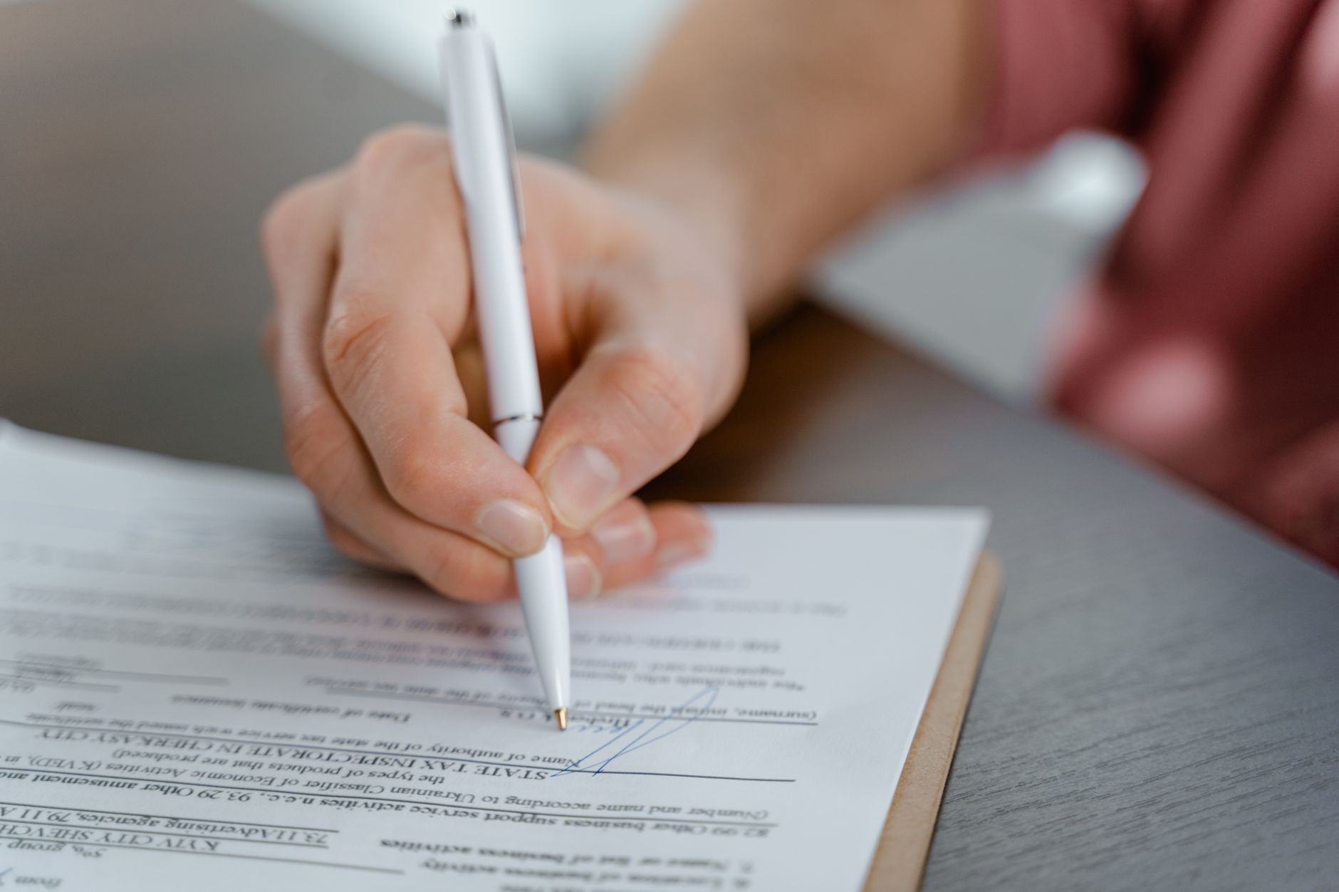 Personne signant un contrat de services funéraires préalables avec un stylo