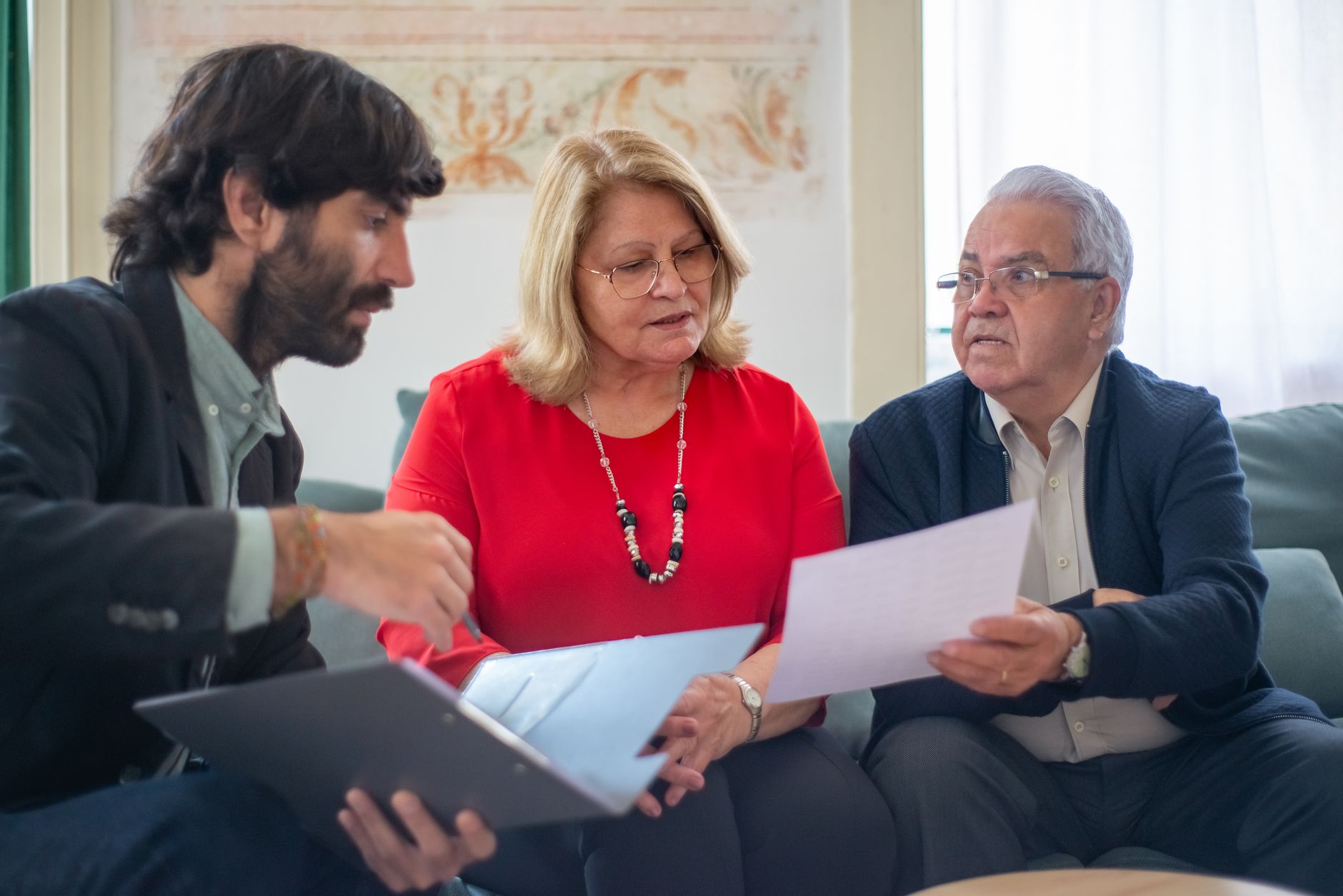 Conseiller funéraire expliquant les options de contrat prépayé en fiducie à un couple âgé