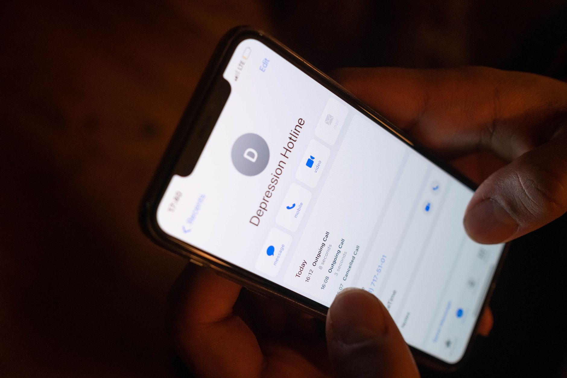Main composant le numéro d'une ligne d'écoute pour recevoir du soutien gratuit après un décès au Québec