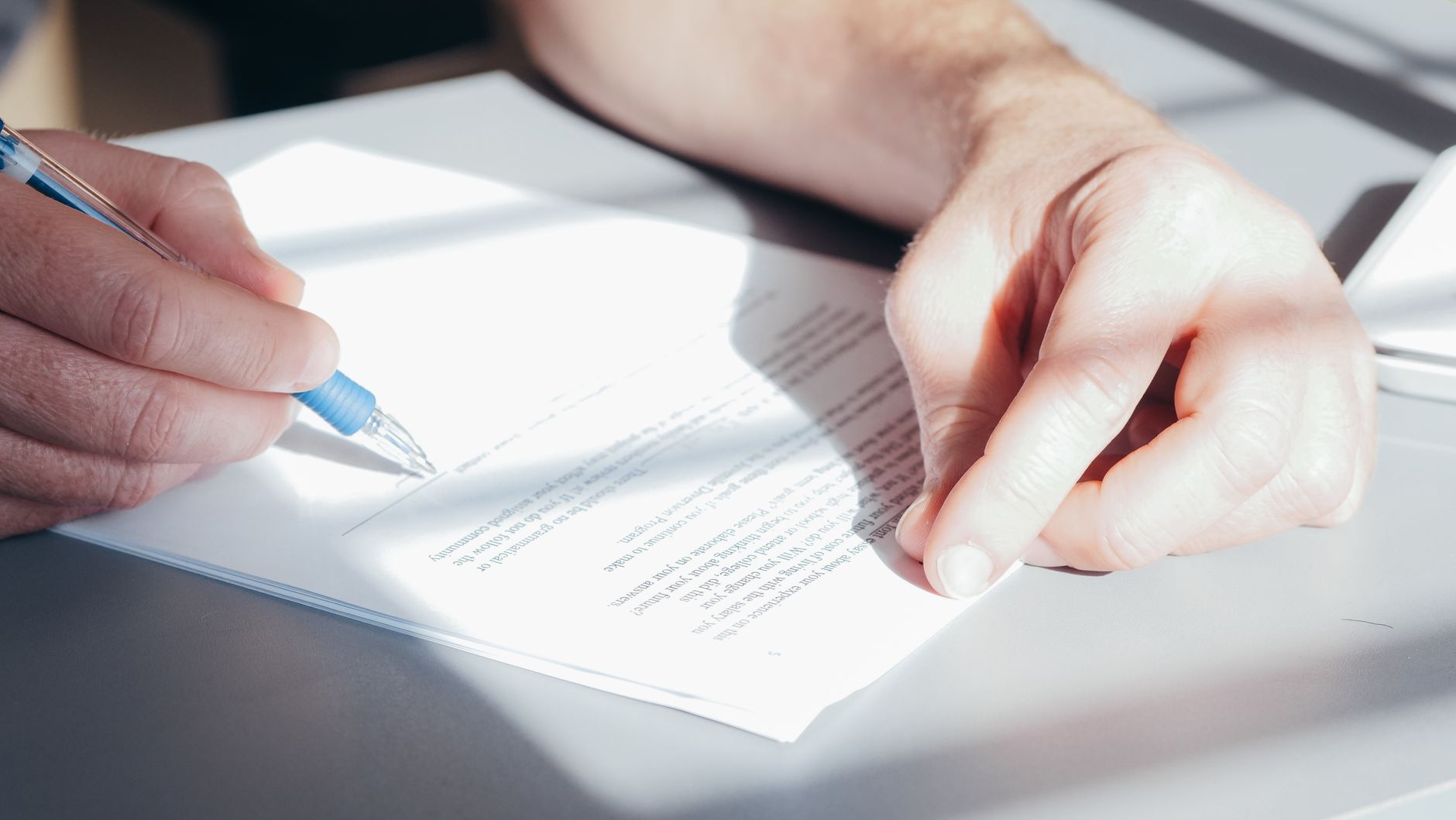 Personne signant un formulaire de consentement au don d'organes avec sa carte d'assurance maladie du Québec