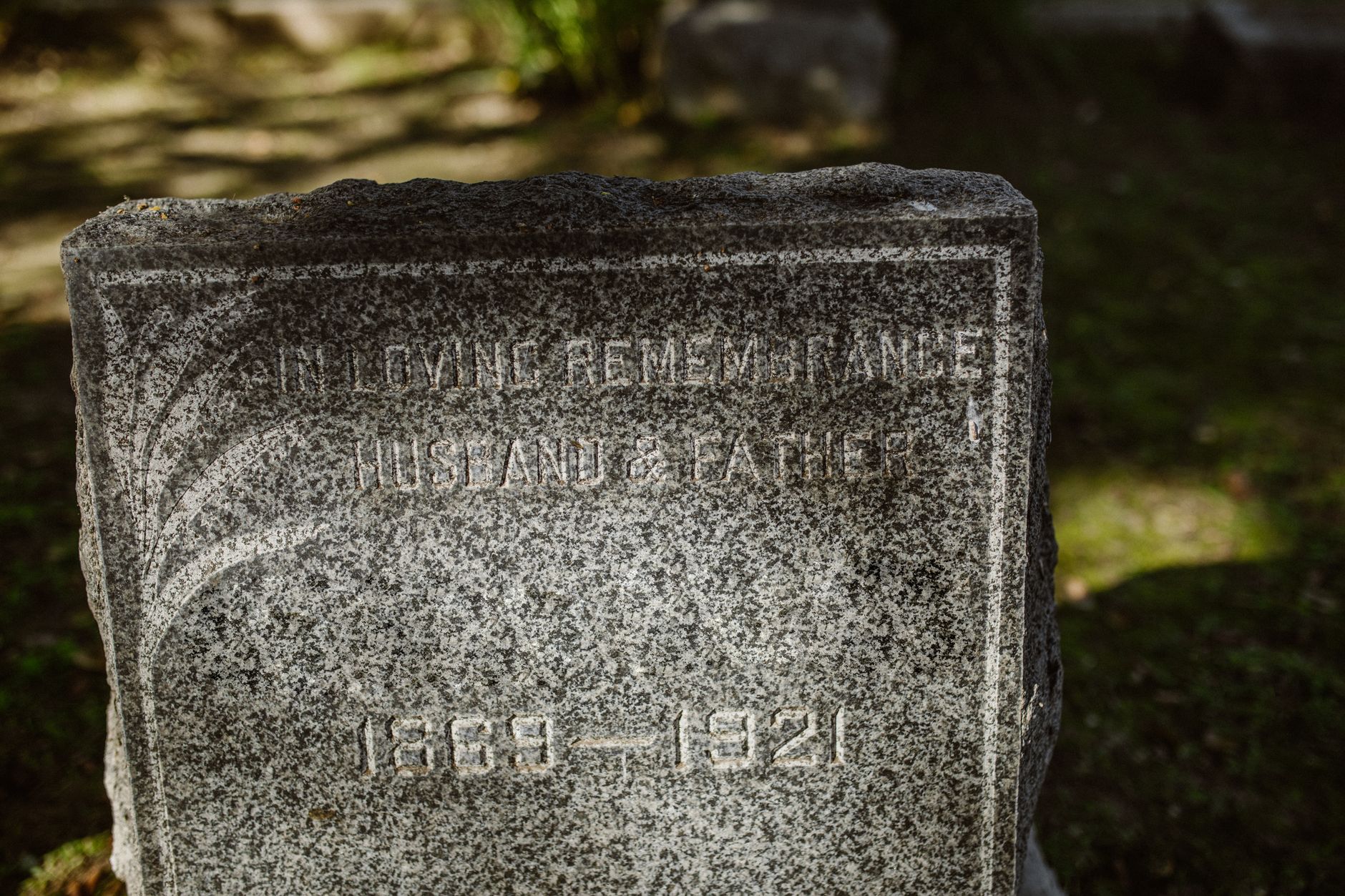 Monument funéraire en granit gris gravé dans un cimetière québécois sous la lumière du matin