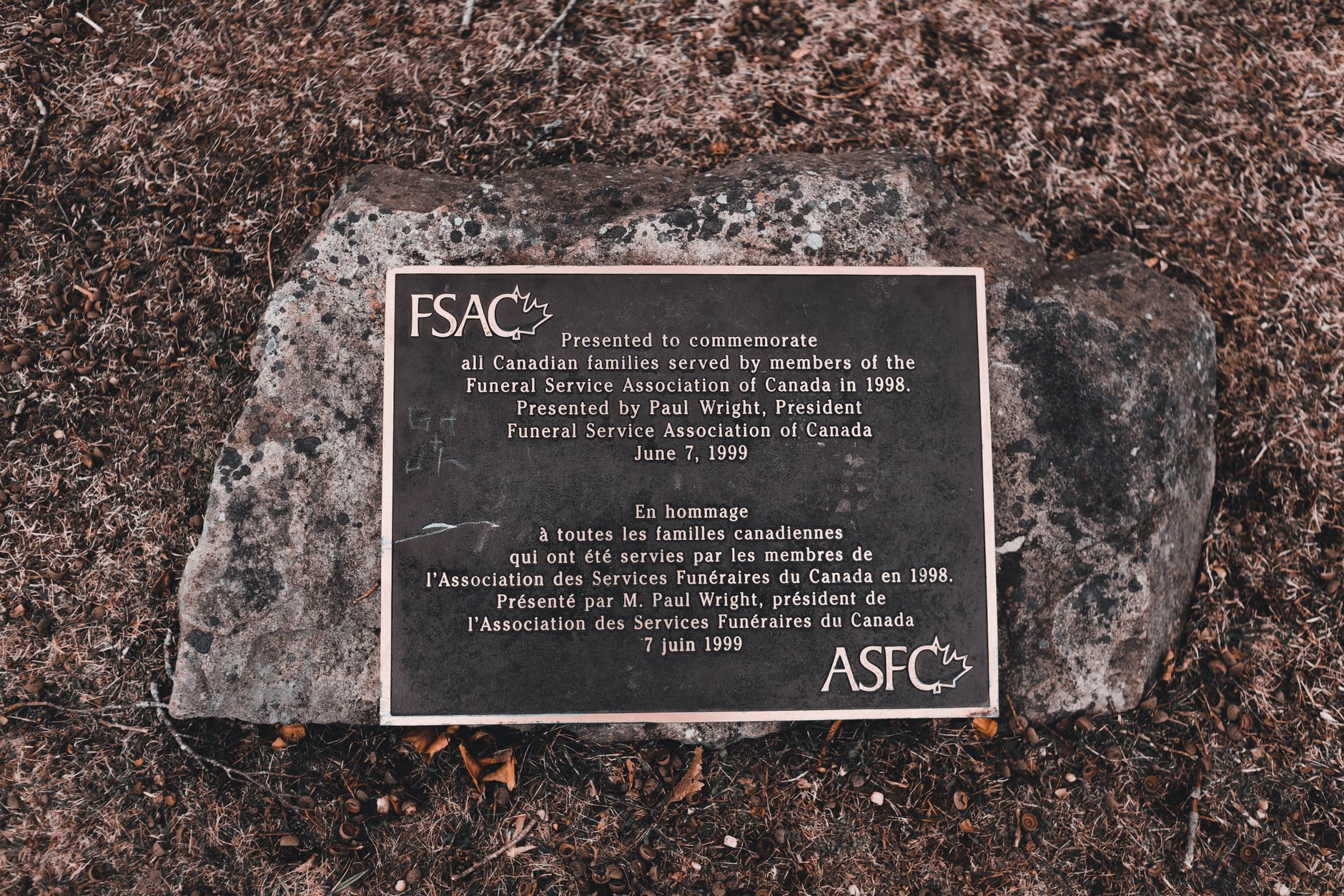 Gros plan sur la gravure d'une plaque commémorative en granit noir aux lettres dorées