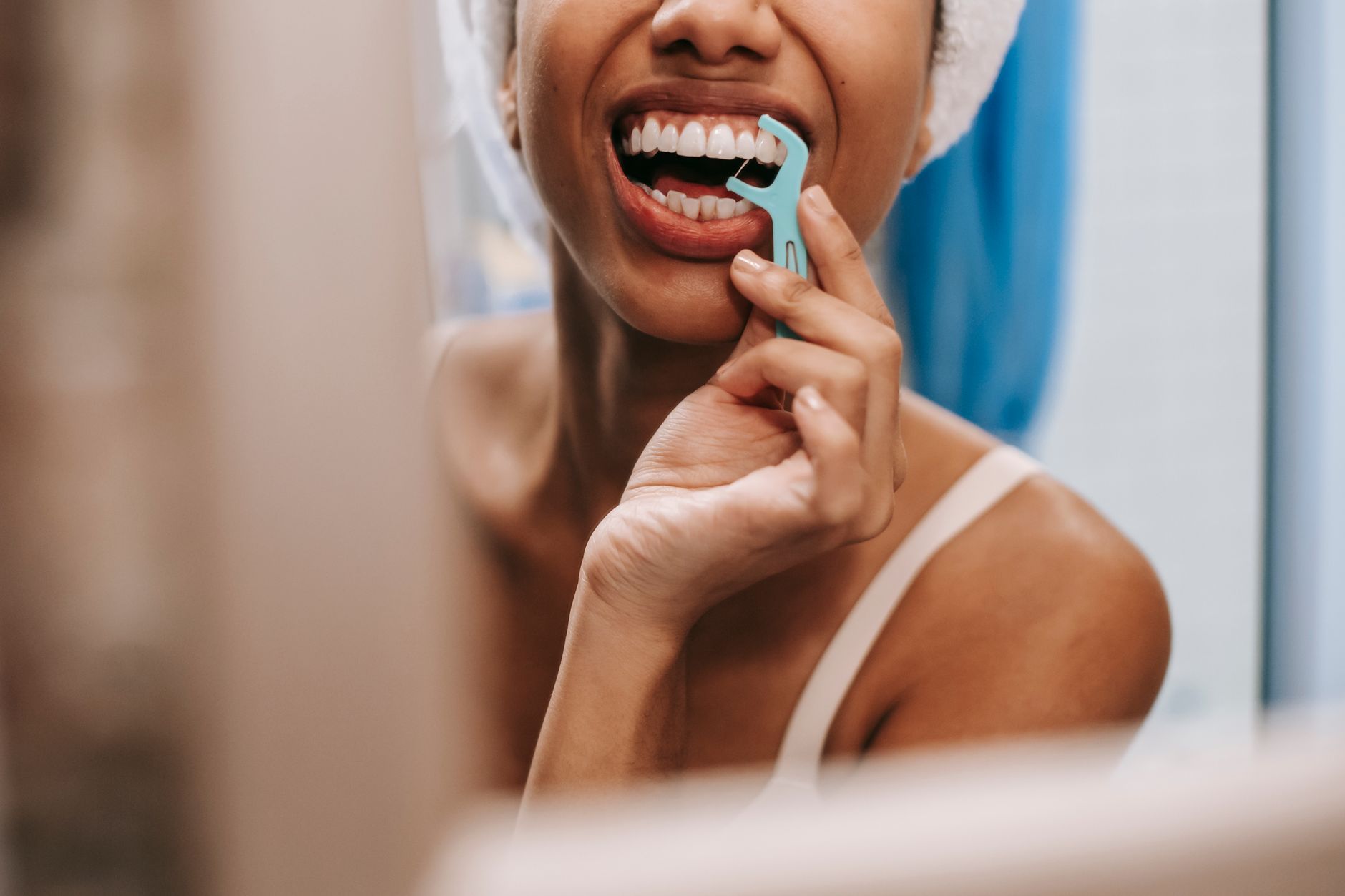 Personne passant la soie dentaire pour prévenir l'inflammation et le saignement des gencives