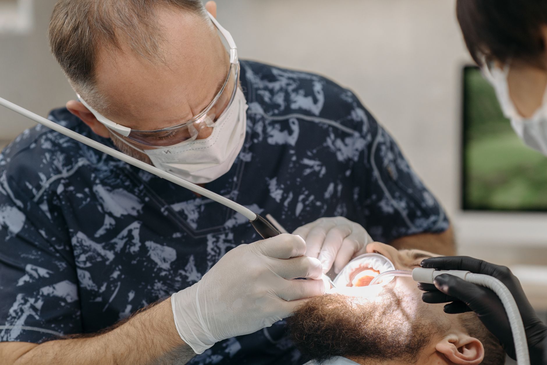 Chirurgien-dentiste réalisant une greffe gencive pour recouvrir une racine dénudée par la récession gingivale