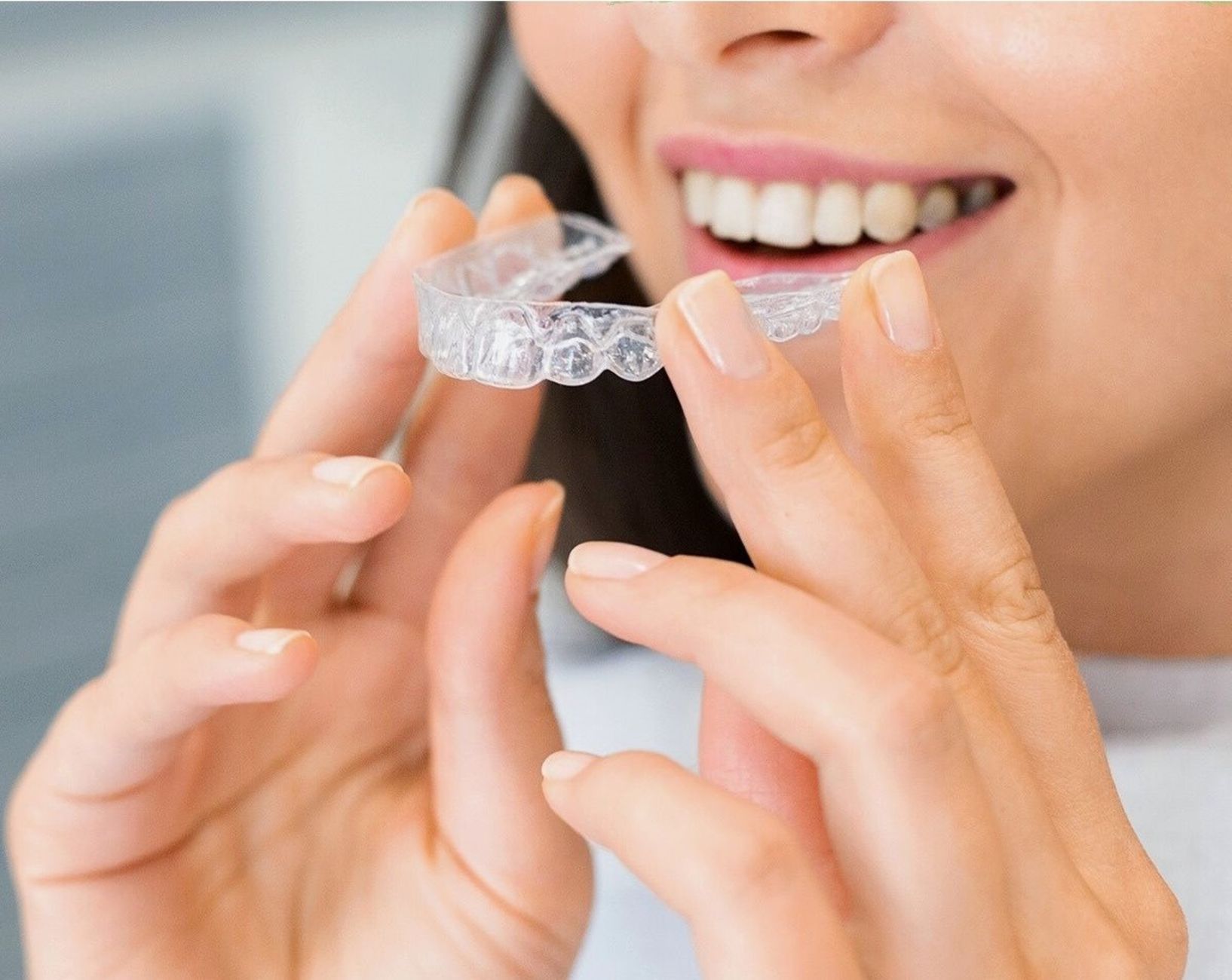 Patiente adulte souriante portant des aligneurs invisibles lors d'un traitement d'orthodontie adulte en clinique dentaire