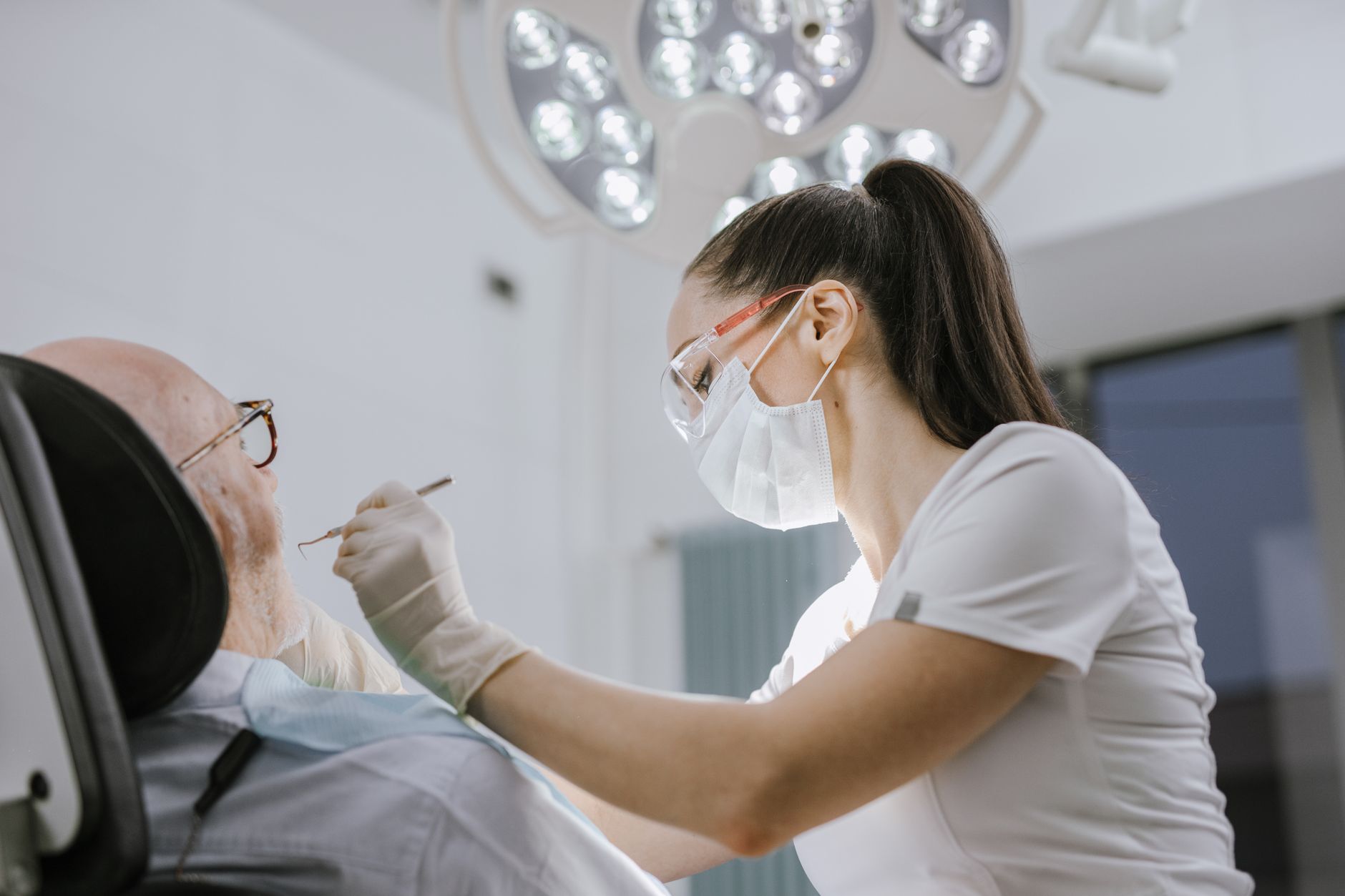 Dentiste drainant le pus d'une infection lors d'une urgence dentaire en clinique