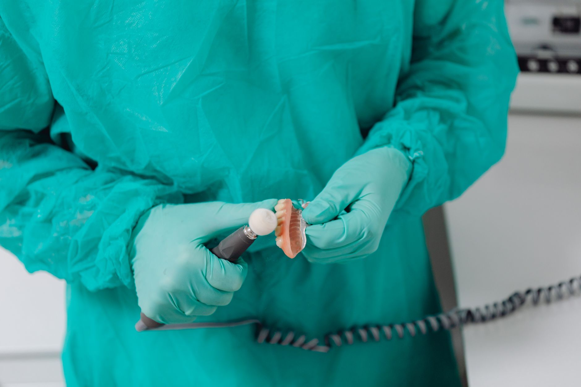 Denturologiste ajustant une prothèse dentaire complète en acrylique dans une clinique au Québec