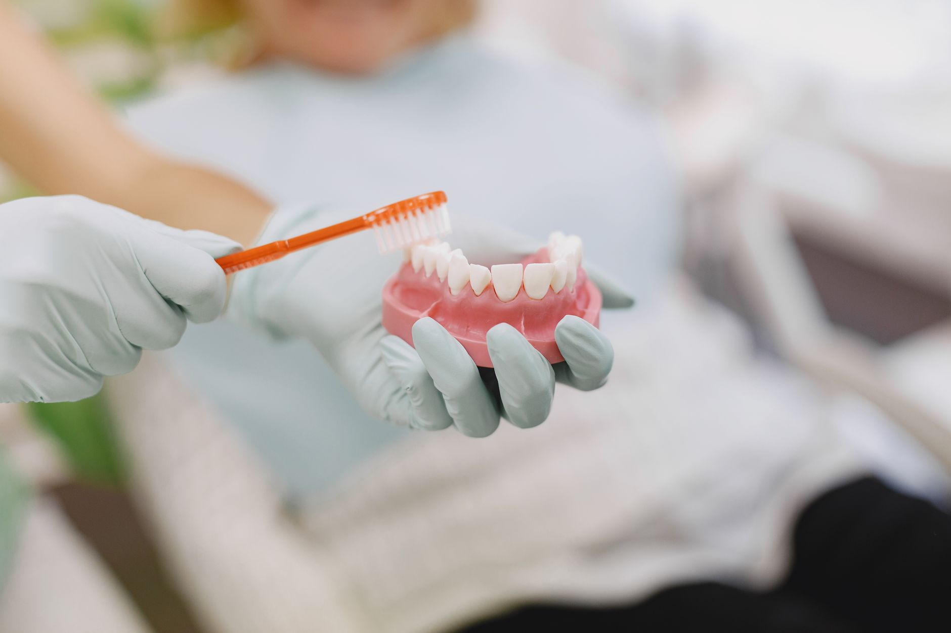 Woman brushing her teeth to extend the lifespan and strength of her dental crowns