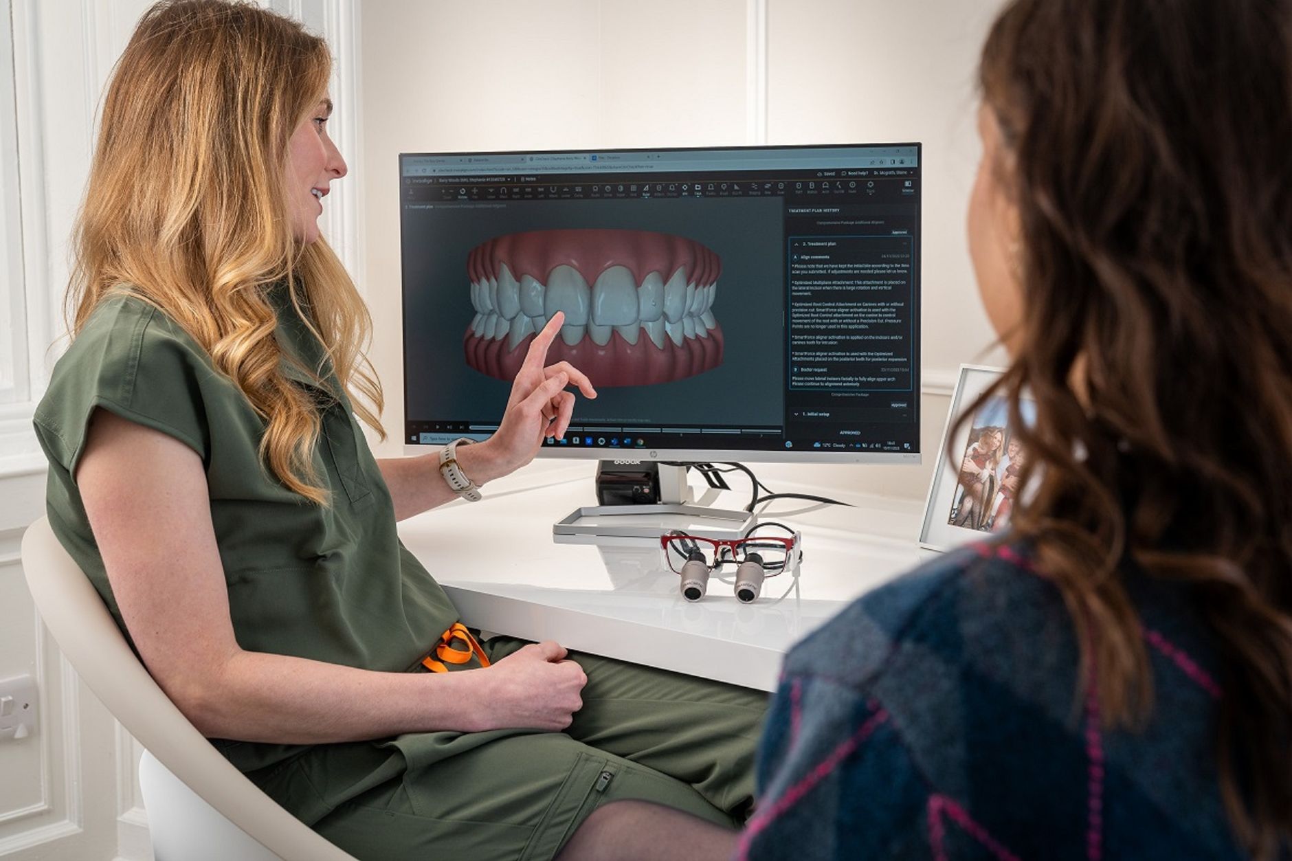 Dentist reviewing a dental implant model with a patient during a consultation in a modern clinic