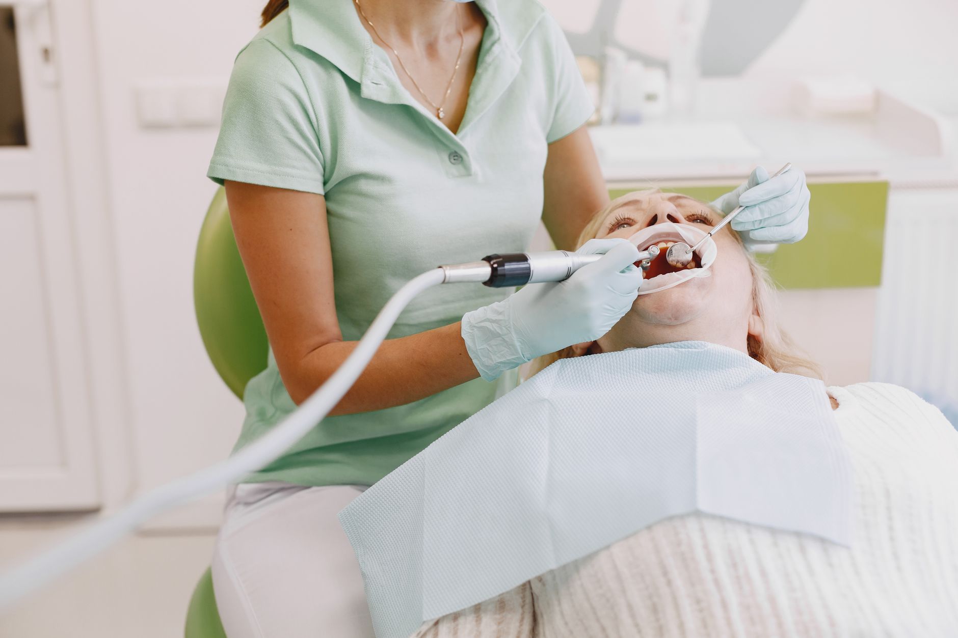 Dental hygienist explaining teeth cleaning frequency to a patient during a routine preventive visit