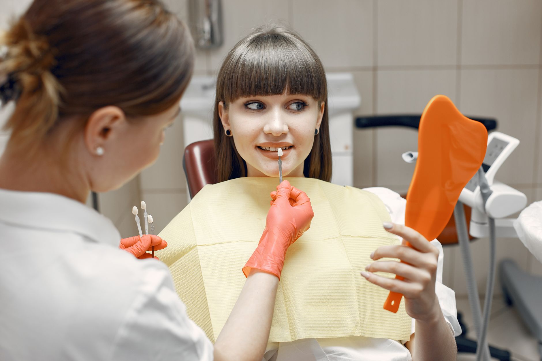 Dentist checking the shade of a dental veneer during an esthetic dentistry consultation