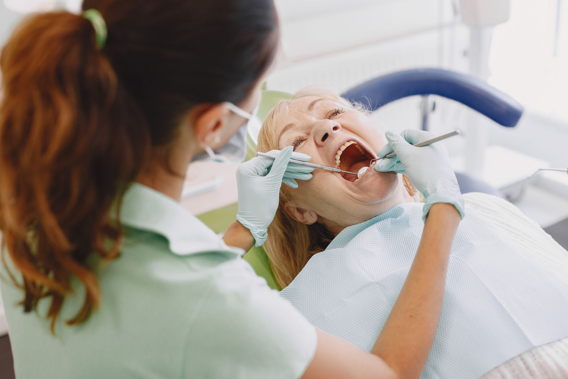 Dentist draining a painful tooth abscess through a small incision during an urgent dental visit
