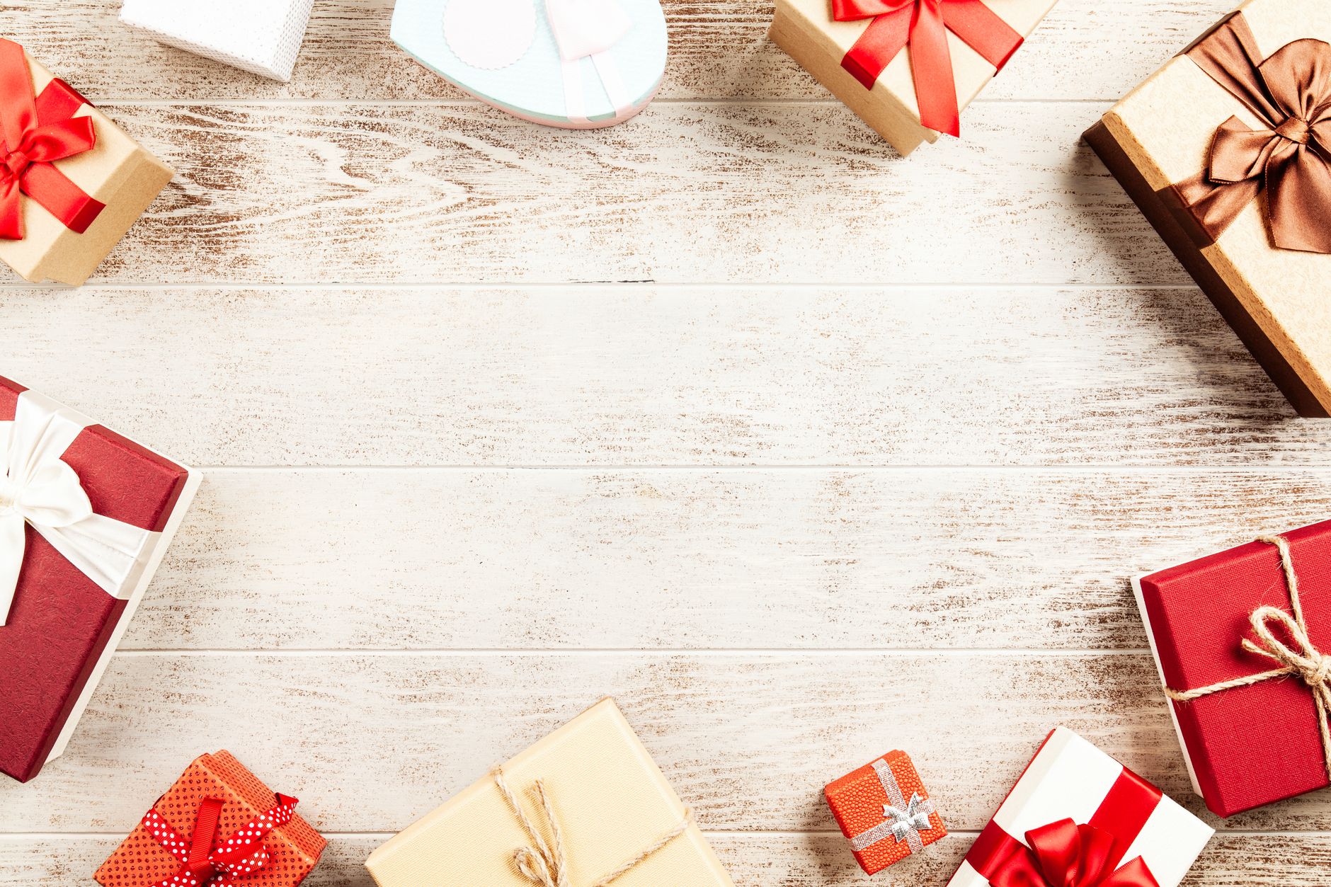 Gift ideas for couples présentées en flat lay avec cadeaux emballés et verres de vin sur une table e