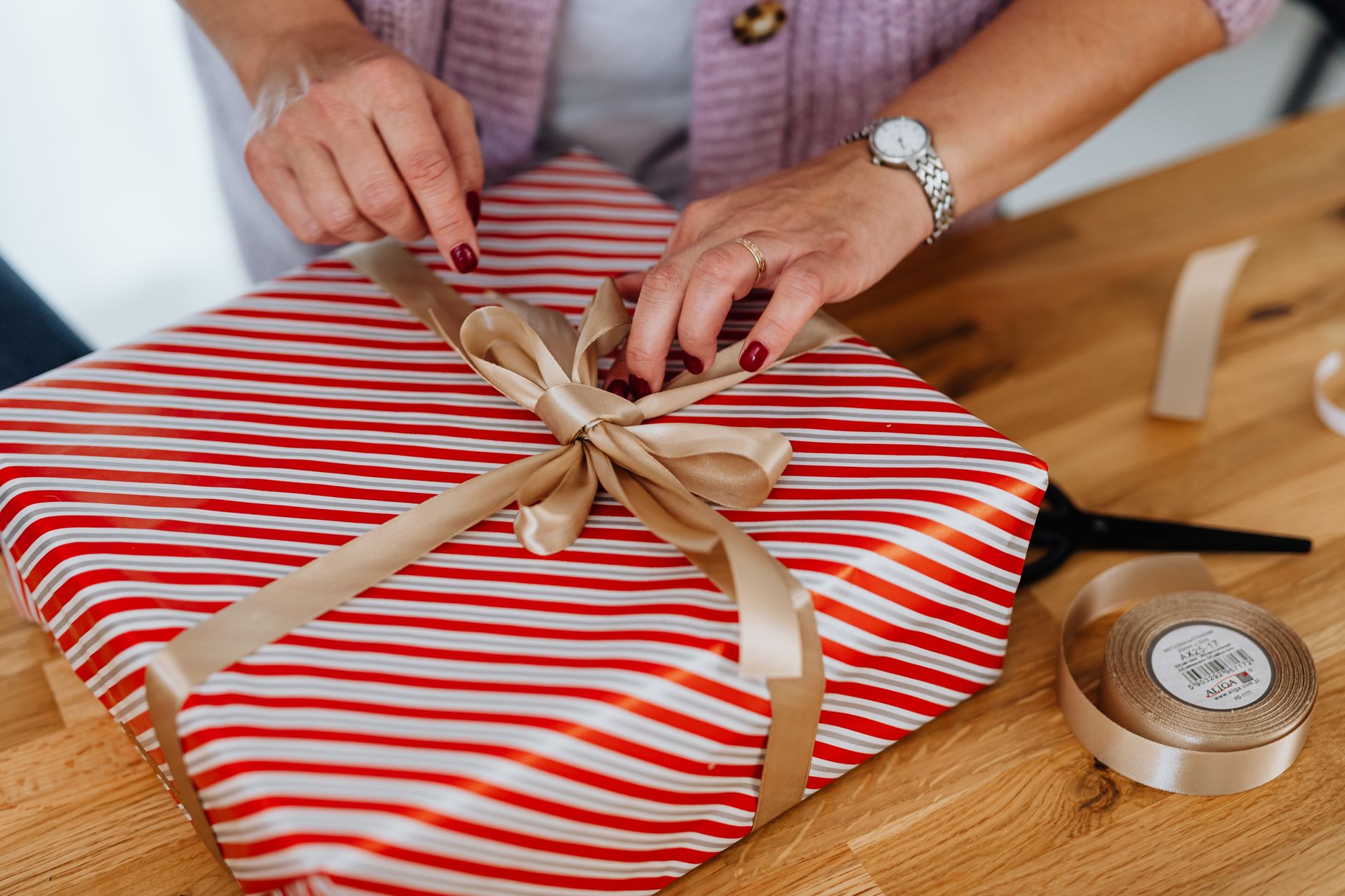 Femme qui déballe un cadeau original fait main au Québec dans un salon chaleureux