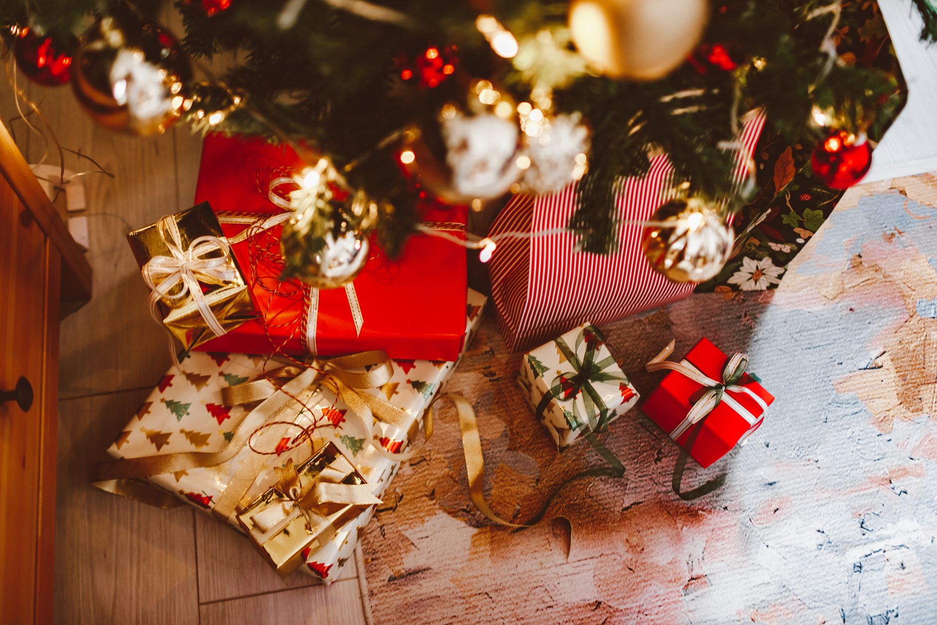 Idées de cadeaux noël québec originaux disposés sous un sapin décoré dans un salon chaleureux au tem