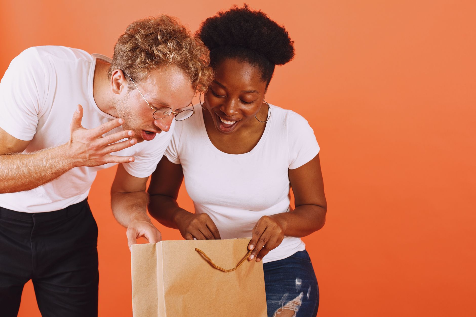 Couple laughing during a shared cooking class, a warm experience-based Valentine's gift idea.